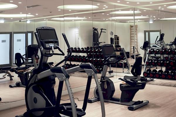 Fitnesscenter im Santo Pure Oia Suites & Villas Hotel mit vielen Geräten und Spiegeln.