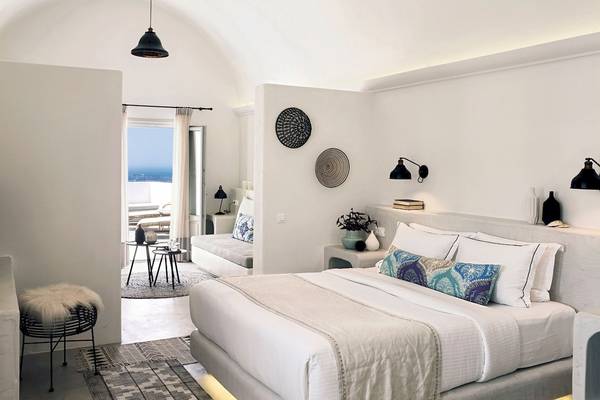 Innenansicht eines Schlafzimmers im Santo Pure Oia Suites & Villas Hotel mit weißem Bett, Dekor und Aussicht