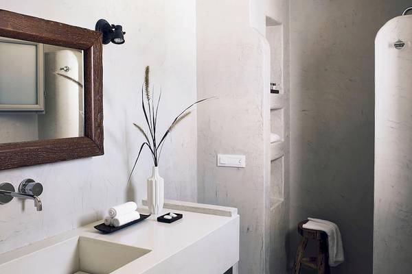 Das Badezimmer von Santo Pure Oia Suites & Villas mit weißem Waschbecken und Spiegel.