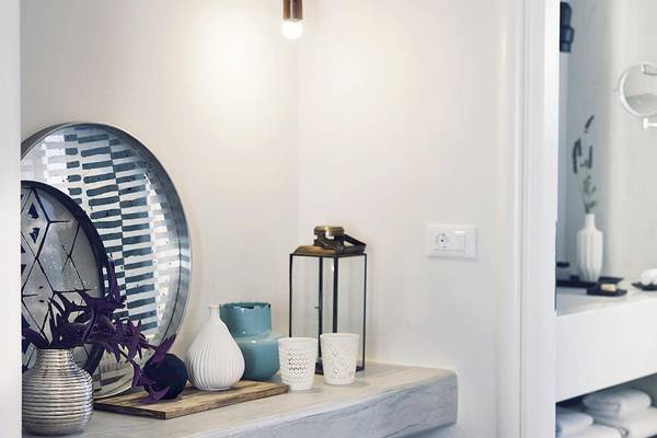 Inneneinrichtung des Santo Pure Oia Suites & Villas mit weißen Vasen und blauen Dekorationsartikeln.