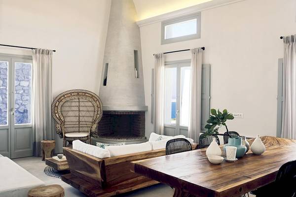 Wohnzimmer von Santo Pure Oia Suites mit Holzsofa, Esstisch und Kamin