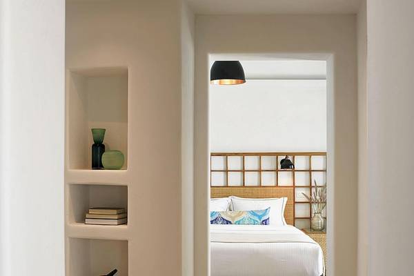 Ein Bett mit Kissen im Zimmer des Santo Pure Oia Suites & Villas Hotels.