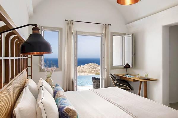 Schlafzimmer mit Meerblick in Santo Pure Oia Suites & Villas mit offenem Balkon und Inneneinrichtung.
