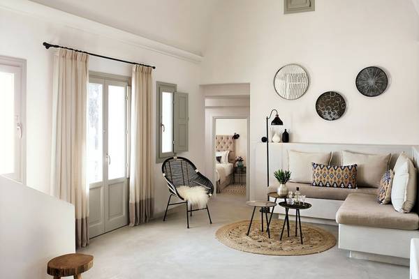 Innenraum des Santo Pure Oia Suites & Villas Hotels mit weißen Wänden, Möbeln und Dekoration.