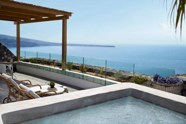 Terrasse mit Meerblick im Santo Pure Oia Suites & Villas, mit Whirlpool, Sonnenliegen und Glasgeländer.