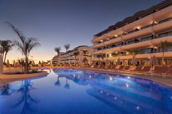 Pool des H10 Atlantic Sunset Hotels bei Nacht, mit Loungeliegen und Palmen