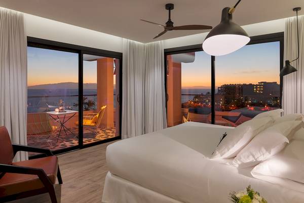 Zimmer im H10 Atlantic Sunset Hotel mit Blick auf das Meer und die Stadt bei Sonnenuntergang.