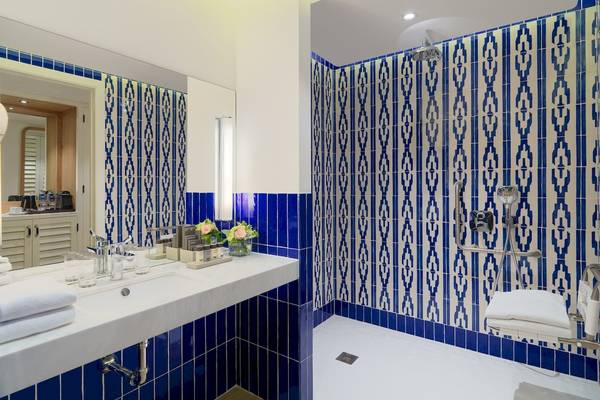 Badezimmer im H10 Atlantic Sunset Hotel mit blauen und weißen Kacheln und einer Dusche