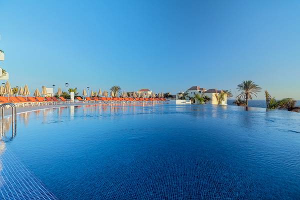 Außenpool des H10 Atlantic Sunset Hotels mit orange Liegestühlen und Palmen