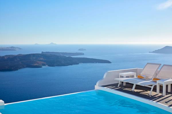 Pool auf der Terrasse des Katikies Chromata Santorini Hotels mit Blick auf das Meer und die Inseln.