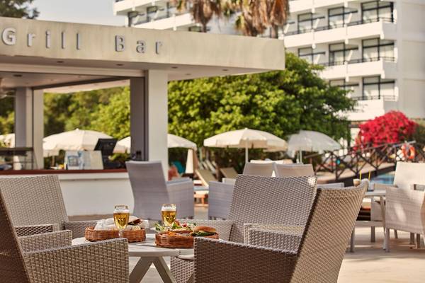 Grill Bar des Grecian Bay Hotels mit Tischen, Stühlen und Getränken vor dem Gebäude