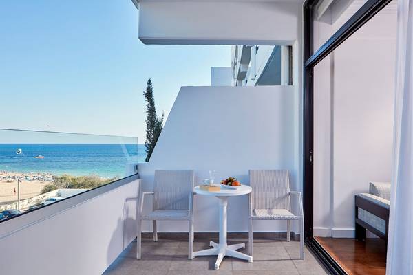 Terrasse des Grecian Bay Hotels mit Aussicht auf den Strand und das Meer