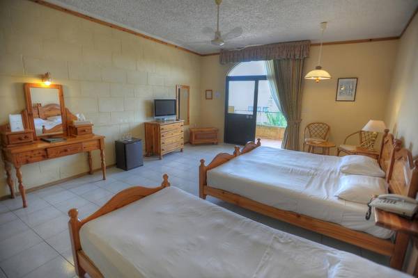 Zimmer in den Cornucopia Bungalows mit zwei Betten, Fernseher und Nachttischen.