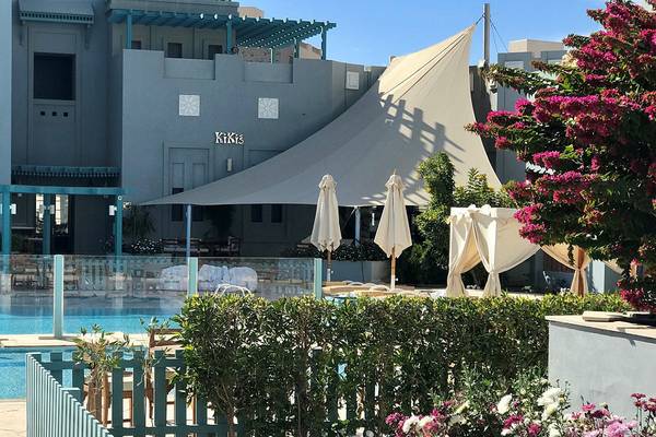 Außenbereich des Fanadir Hotel El Gouna mit Pool, Sonnenschirmen und Pflanzen.