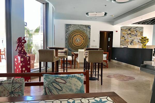 Lounge-Bereich des Fanadir Hotel El Gouna mit Barhockern, Kunstwerken und einem Tisch.