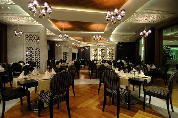 Das elegante Restaurant des Gold Island Hotels mit gedeckten Tischen und hängenden Kronleuchtern.