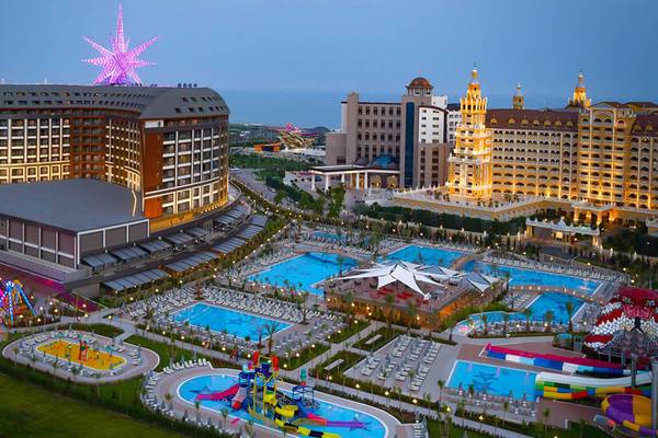 Außenansicht des Royal Seginus Hotels und Resorts mit Swimmingpools, Spielplatz und Leuchtstern.