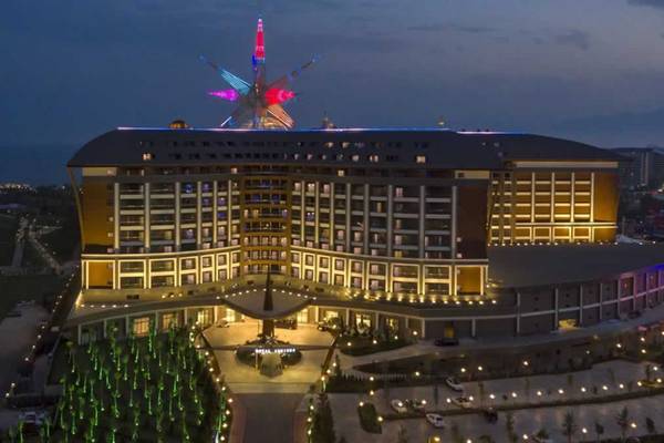 Das Royal Seginus Hotel ist bei Nacht beleuchtet und zeigt eine farbenfrohe Dekoration auf dem Dach.