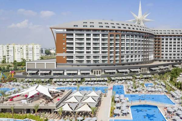 Außenansicht des Royal Seginus Hotels mit Swimmingpools und Sternendekoration.