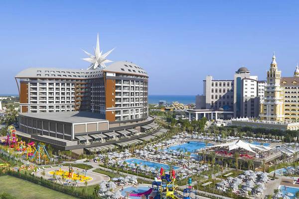 Luftaufnahme des Royal Seginus Hotels mit Swimmingpools und Spielplatz im Vordergrund.