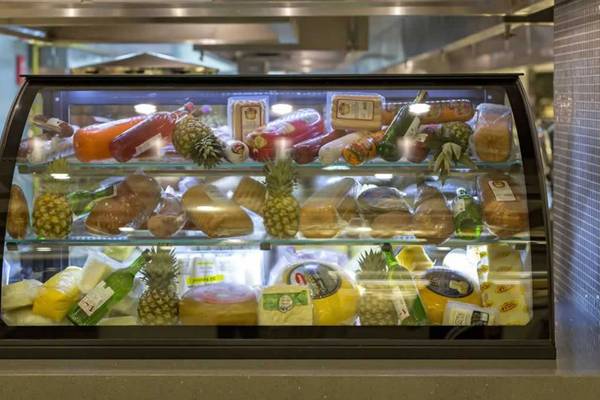Ein Speiseschrank im Restaurant des Royal Seginus Hotels, gefüllt mit verschiedenen Lebensmitteln wie Brot, Käse, Obst und Getränken.