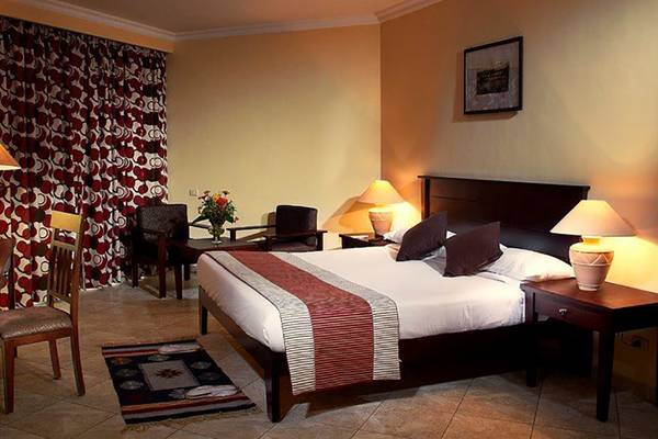 Ein Schlafzimmer im Magic Tulip Resort mit Bett, Lampen, Tisch und Stühlen.