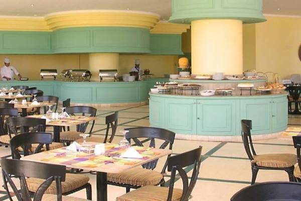Innenansicht des Restaurants im Magic Tulip Resort mit gedeckten Tischen, Buffet und Köchen.