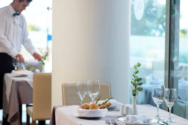 Kriti Beach Hotel Restaurant Tisch mit Gläsern, Besteck und Pflanzendekor