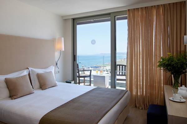 Zimmer im Kriti Beach Hotel mit Blick auf das Meer und Balkon.