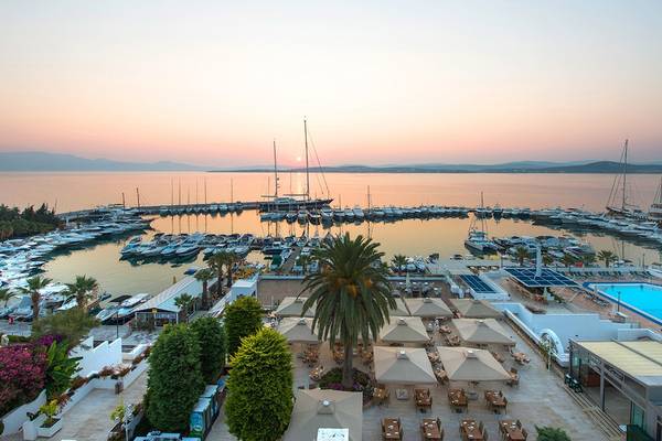 Luftaufnahme des Altin Yunus Hotel & Spa mit Blick auf den Hafen und Sonnenuntergang.