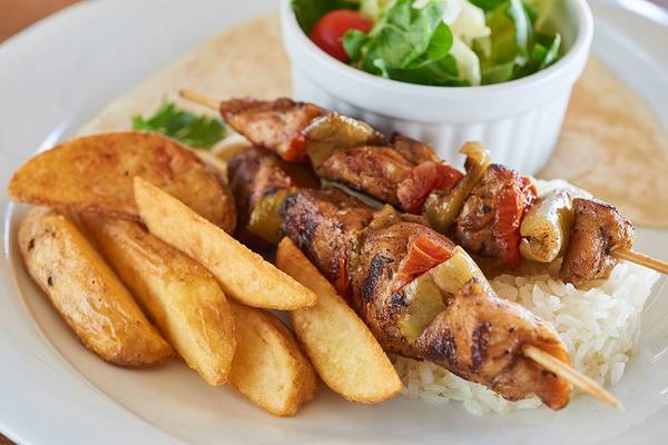 Ein Teller mit gegrilltem Fleisch, Pommes und Salat.