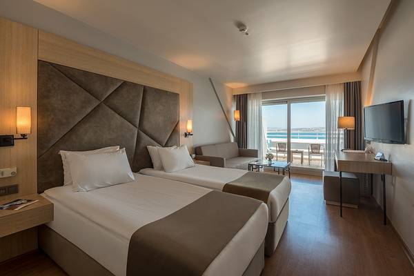 Hotelzimmer mit zwei Betten und Meerblick von der Terrasse.
