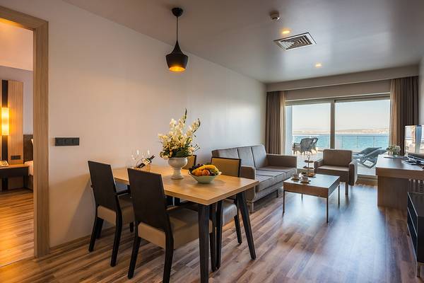 Wohnzimmer des Altin Yunus Hotel & Spa mit Tisch, Sofa und Meerblick.