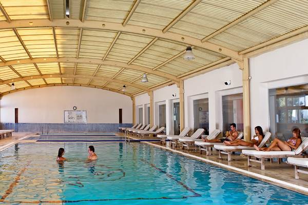 Schwimmbad im Altin Yunus Hotel & Spa mit mehreren Personen, die schwimmen und sich entspannen.