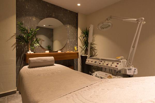 Behandlungsraum im Altin Yunus Hotel & Spa mit Massageliege, Lampe und Spiegel.