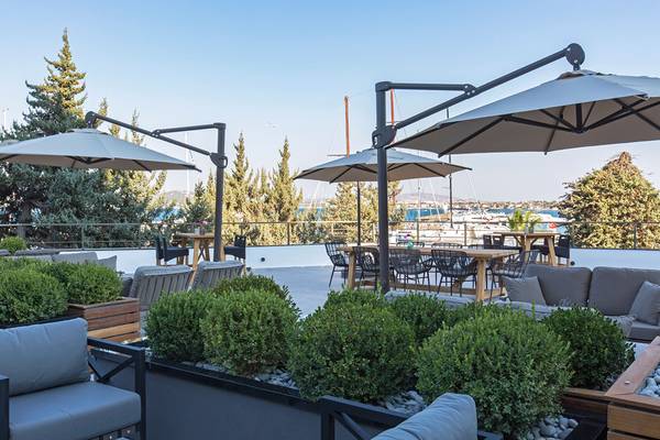 Terrasse des Altin Yunus Hotel & Spa mit Tischen, Stühlen und Sonnenschirmen