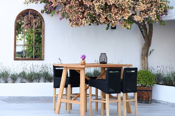 Holztisch im Garten des Altin Yunus Hotel & Spa mit vier Stühlen und einer Blumenvase.