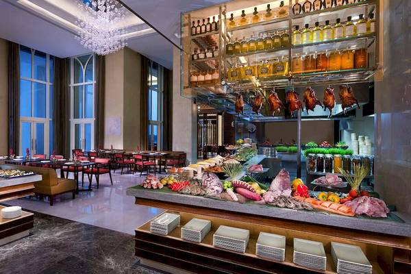 Innenansicht des Restaurants im Anantara Eastern Mangroves Abu Dhabi Hotel mit Buffet und Tischen.