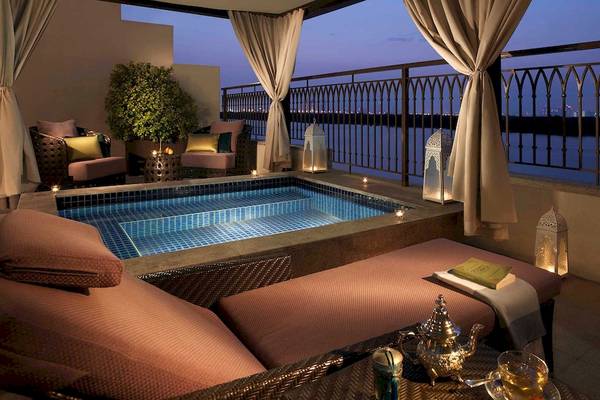 Balkon des Anantara Eastern Mangroves Abu Dhabi Hotels mit Swimmingpool, Loungesofa und Stadtblick