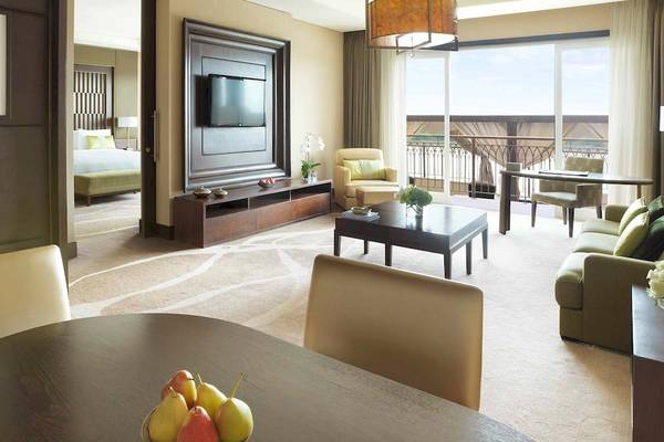 Innenansicht einer Suite im Anantara Eastern Mangroves Abu Dhabi Hotel mit Möbeln und Aussicht.
