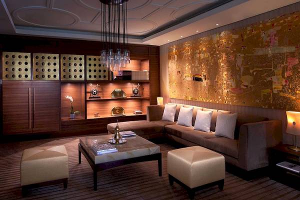 Wohnbereich im Anantara Eastern Mangroves Abu Dhabi Hotel mit einer L-förmigen Couch, einem Tisch und Dekor.