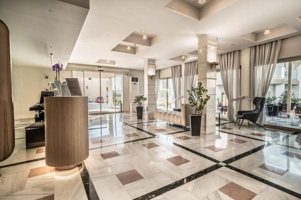 Empfangsbereich des Adele Beach Hotels mit Marmorboden und Sitzbereich.