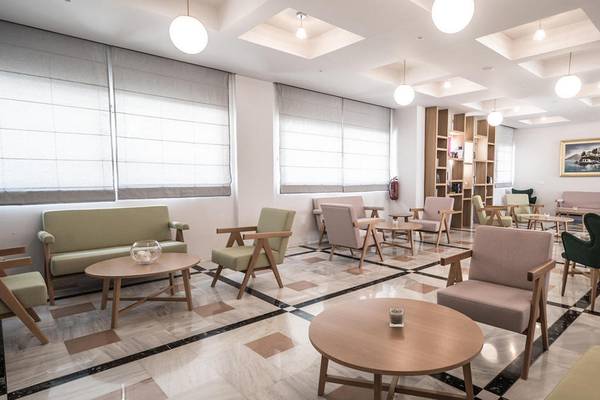 Lobby des Adele Beach Hotels mit Sitzgelegenheiten und Tischen.