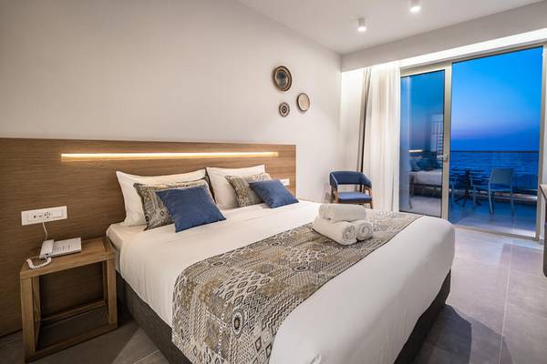 Hotelzimmer im Adele Beach Hotel mit großem Bett und Meerblick.