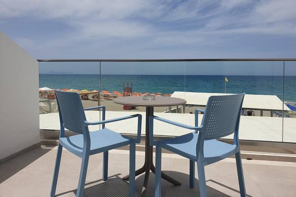 Balkon im Adele Beach Hotel mit Blick auf das Meer und eine gelbe Flagge.