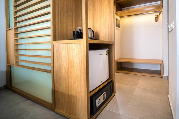 Ein Zimmerschrank im Adele Beach Hotel mit Minibar, Safe und Kaffeemaschine.