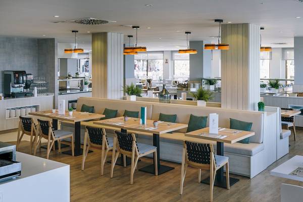 Innenbereich des Restaurants des NYX Ibiza Hotels mit modernen Möbeln, Tischen, Stühlen und Pflanzen.