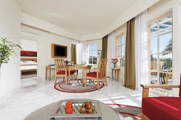 Inneneinrichtung des Mövenpick Resort & Spa El Gouna mit Tisch, Stühlen und Balkon.