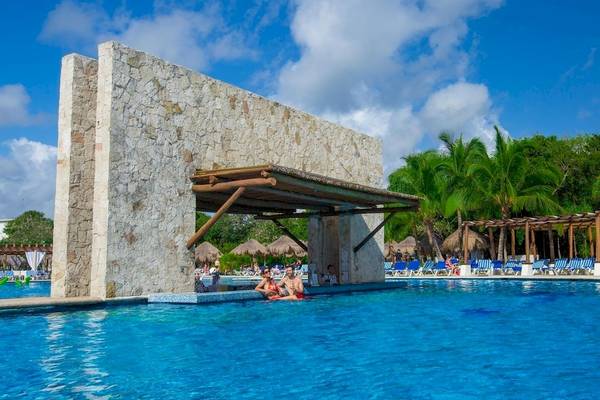 Außenpoolbereich des Grand Sirenis Riviera Maya Resort & Spa mit Gäste, die in einem blauen Pool schwimmen