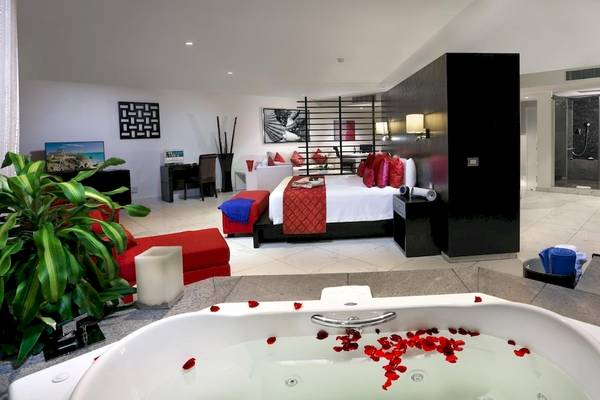 Schlafzimmer im Grand Sirenis Riviera Maya Resort mit Kingsize-Bett, Whirlpool und Badezimmer